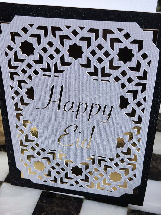 Happy Eid card featuring intricate laser cut Islamic geometric design in gold and black.