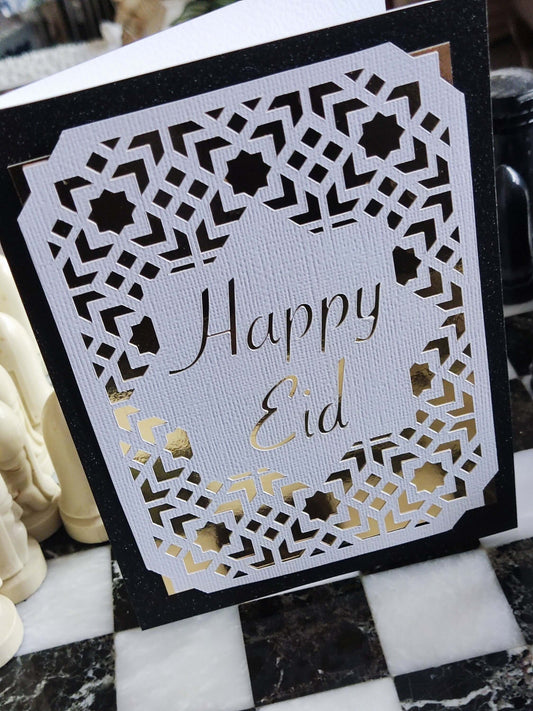 Happy Eid card featuring elegant laser cut geometric design in gold and white on a black background.