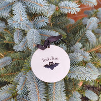 Close-up of Halloween bauble with bat and Trick or Treat design, tied with black ribbon.