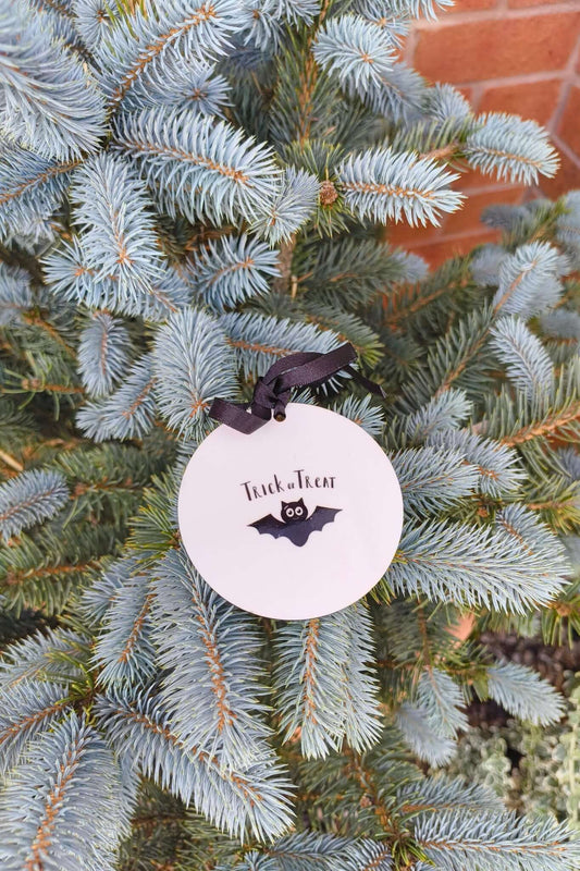 Close-up of Halloween bauble with bat and Trick or Treat design, tied with black ribbon.