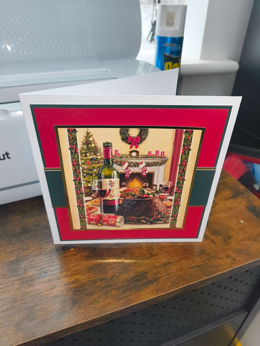 Handmade Christmas card featuring a cosy fireplace scene with wine, gifts, and a decorated tree.