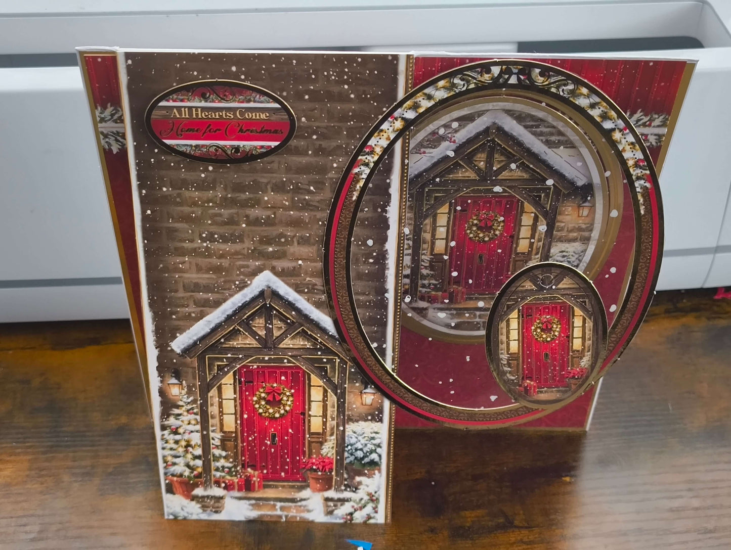 Handmade Christmas card featuring a cozy snow-covered door with a decorative wreath.