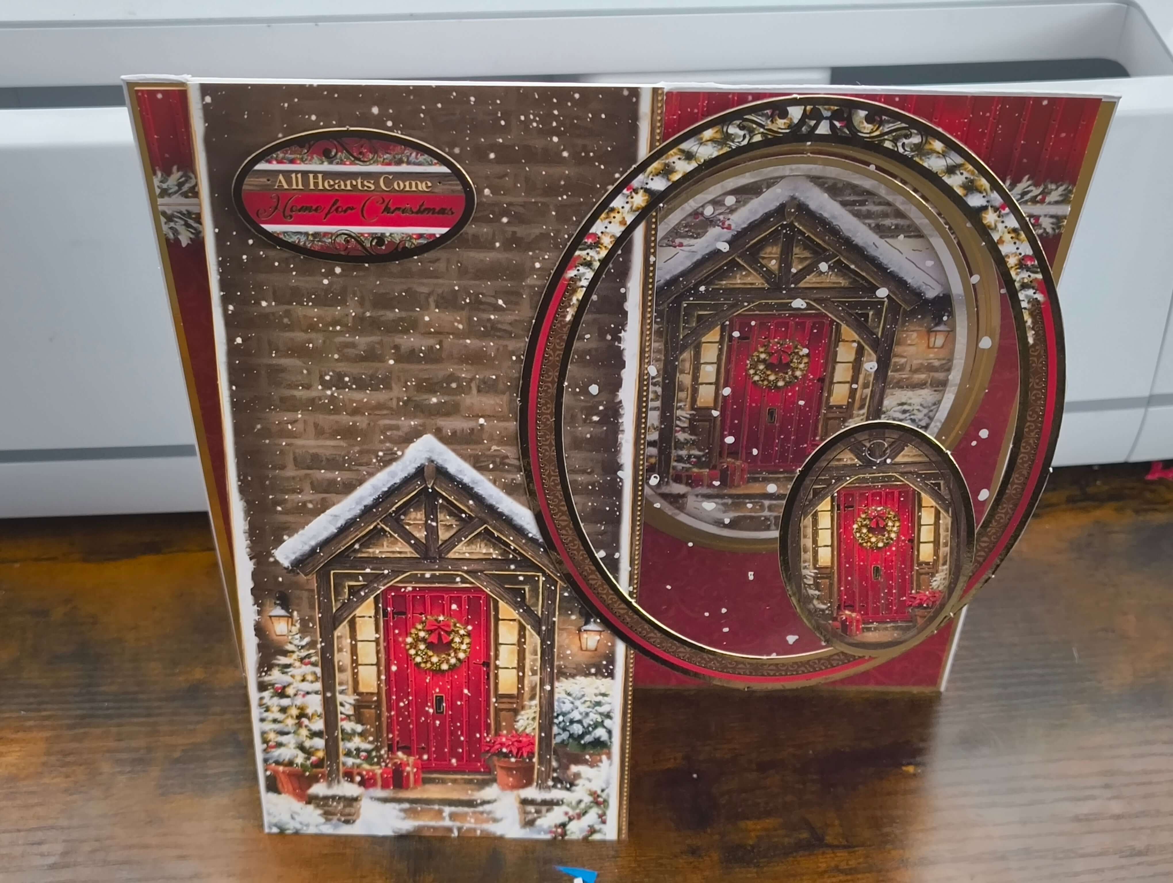 Handmade Christmas card featuring a cozy snow-covered door with a decorative wreath.