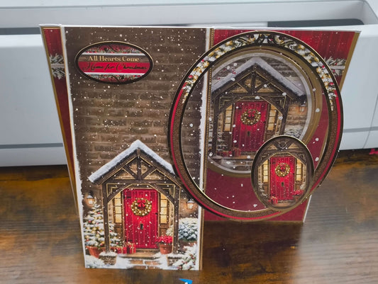 Handmade Christmas card featuring a cozy snow-covered door with a decorative wreath.