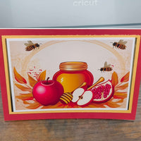 Vibrant Rosh Hashanah card with honey, apples, and pomegranates, celebrating the Jewish New Year.