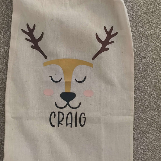 Personalised Christmas gift sack with reindeer face, gold foil detailing and name Craig, handmade on natural cotton
