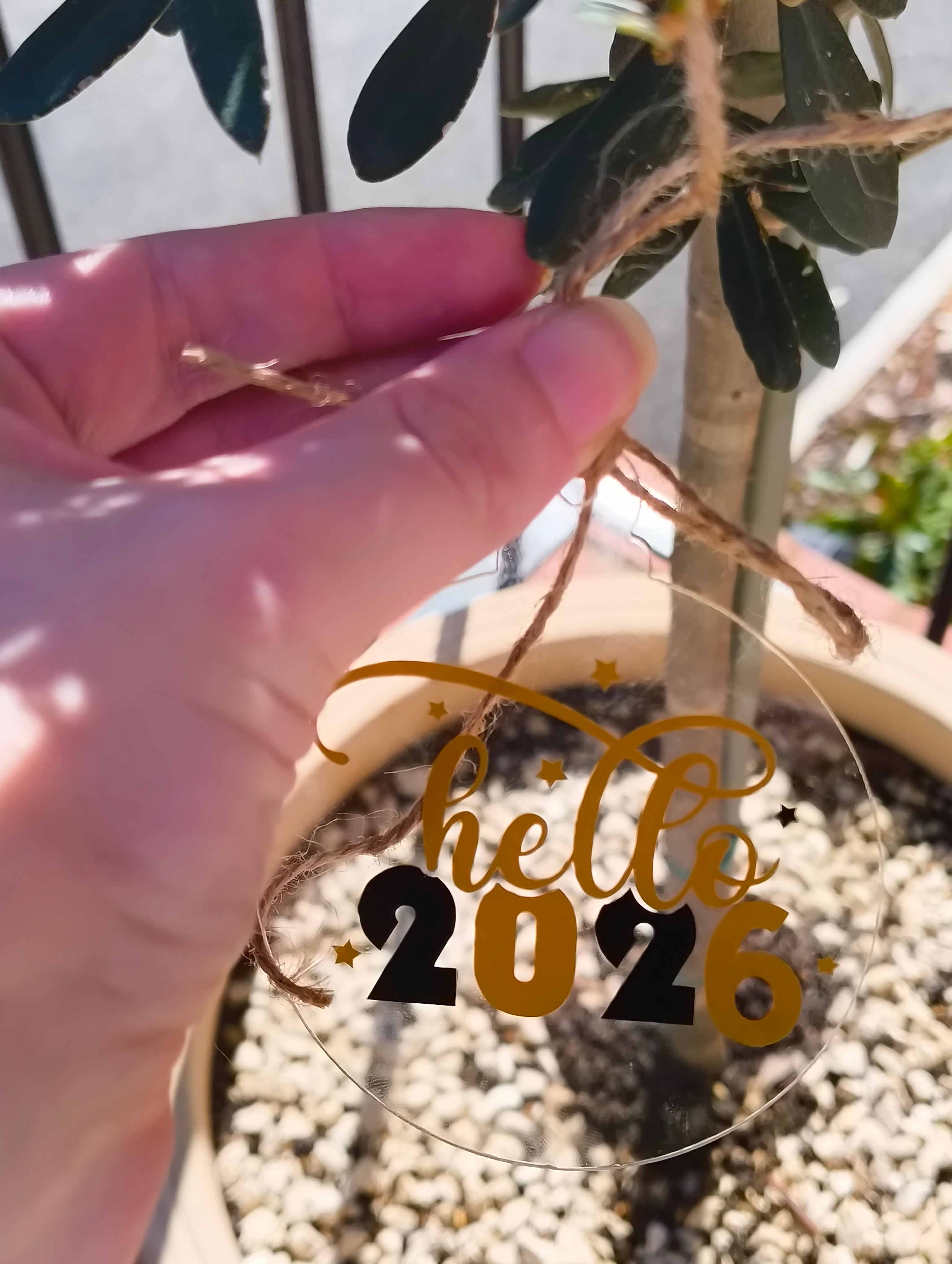 Acrylic New Year bauble ornament reading 'hello 2026', hanging from a plant, perfect for festive decoration.
