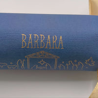 Detailed close-up of handmade cracker in navy with gold foiled name ‘Barbara’ and Nativity manger design.