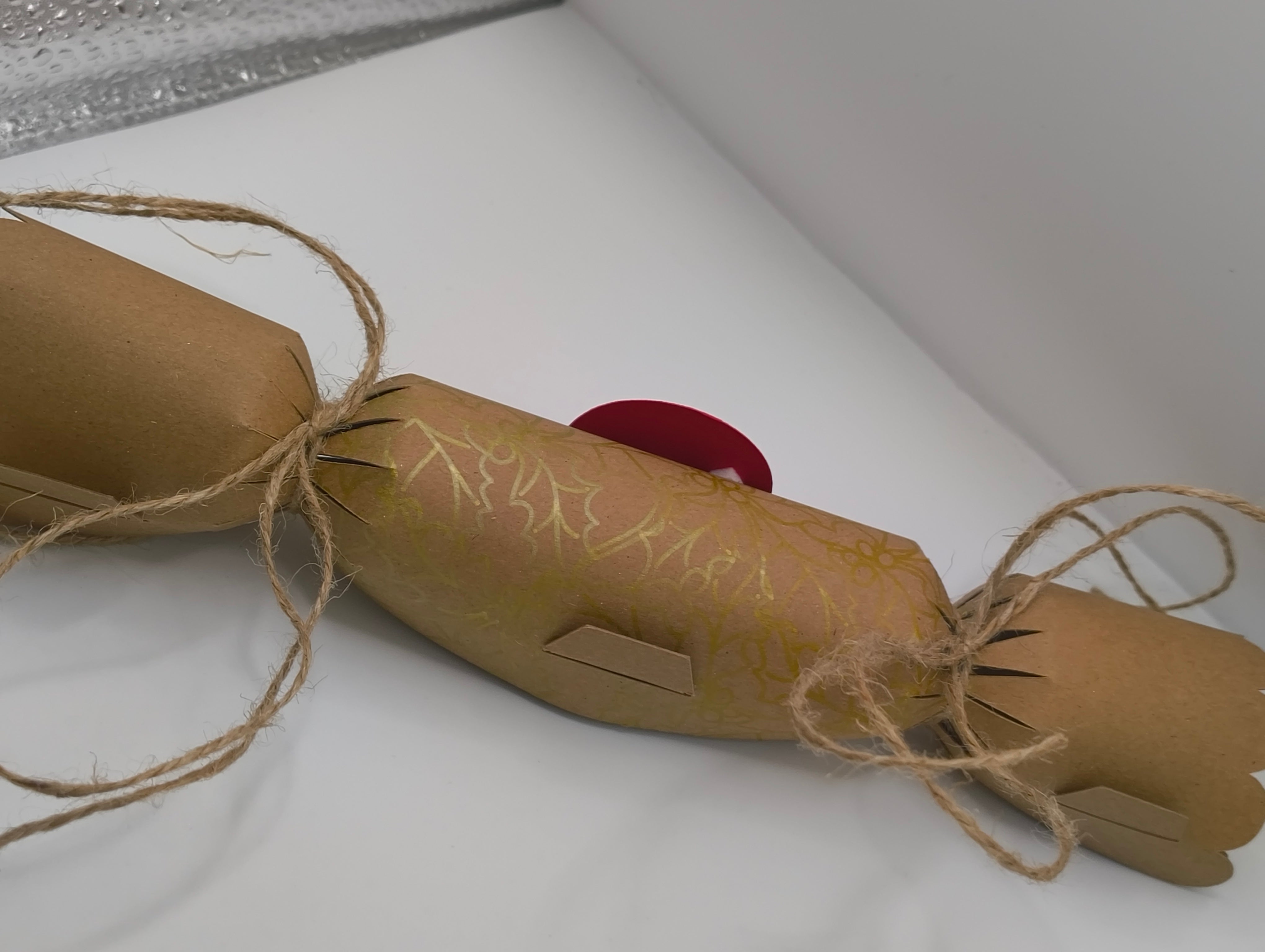 Eco-friendly Christmas crackers with gold holly design and jute twine, perfect for festive celebrations.