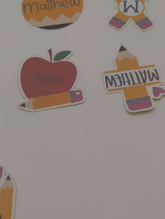 Personalised School Name Stickers showcasing apple, pencil, and name designs for kids' school supplies.