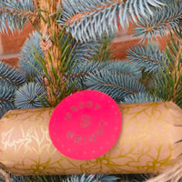 Eco-Friendly Christmas Crackers with gold holly design and jute twine on a Christmas tree.