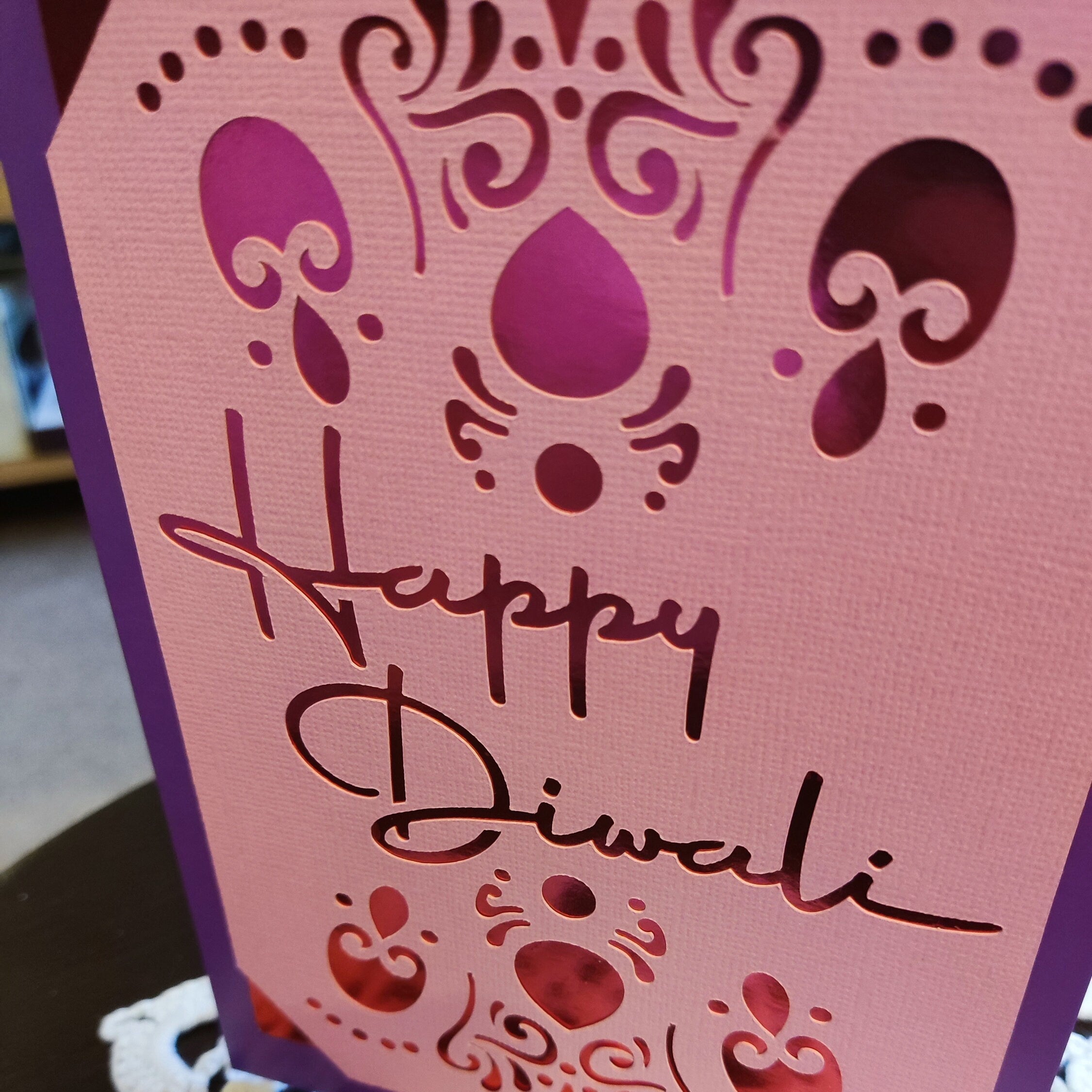 Handmade Diwali card featuring elegant cut-out design with the words 'Happy Diwali' in a beautiful font.