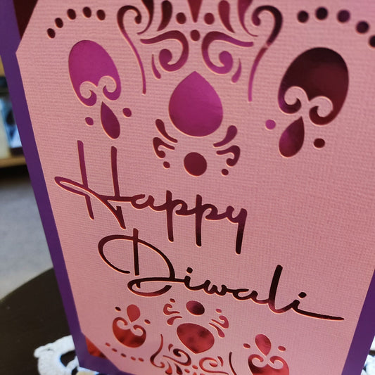 Handmade Diwali card featuring elegant cut-out design with the words 'Happy Diwali' in a beautiful font.