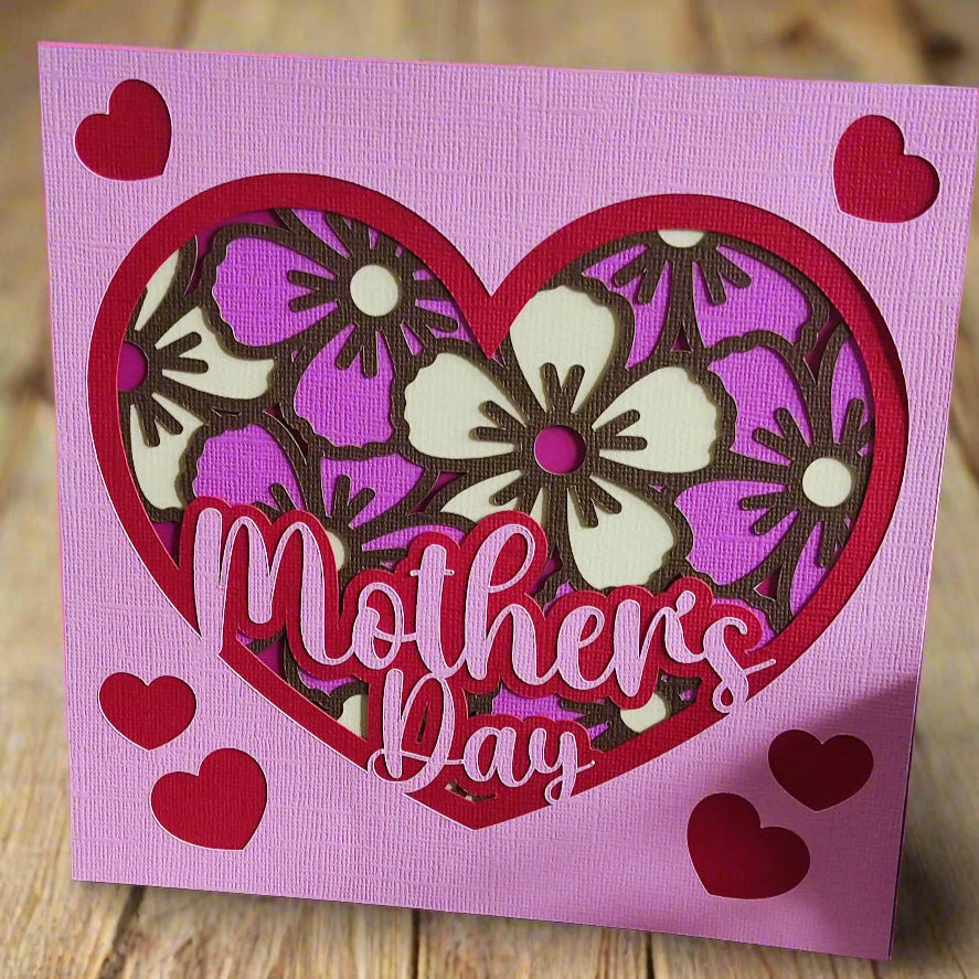 Handmade Mother's Day floral heart card in pink and purple with layered floral design and hearts.