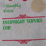 Close-up of a Christmas bag with "North Pole Post", "Naughty & Nice", "Open December 25", and "Overnight Service For" text.