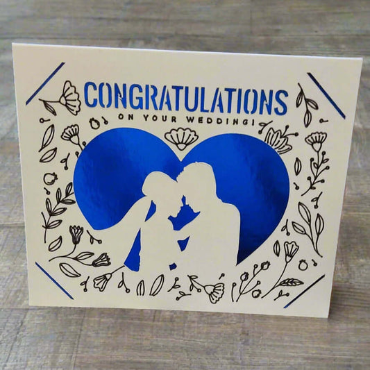 Handmade wedding congratulations card with blue heart, silhouette couple, and floral design.