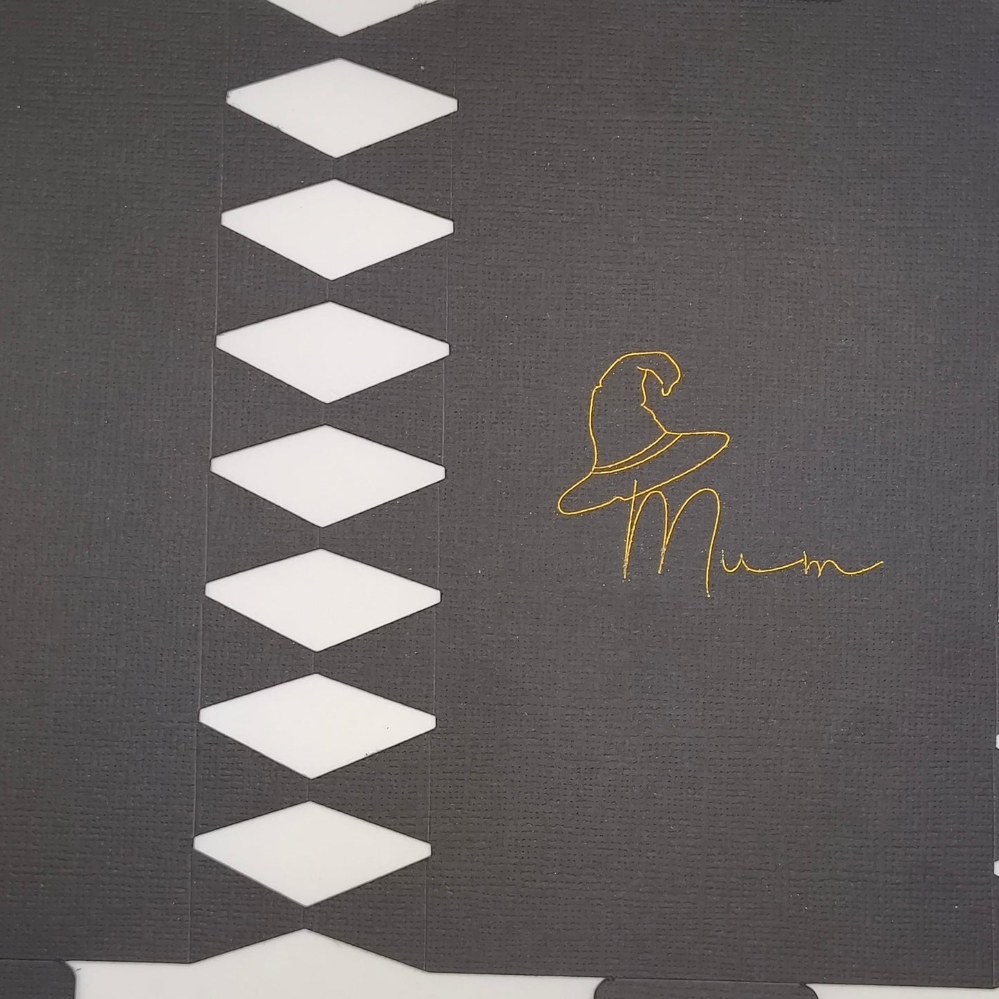 Close-up of black cracker card template showing gold foil witch hat and “Mum” lettering