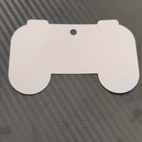 Hollow outline of a gaming controller gift tag on black carbon fiber background for personalized gifts.