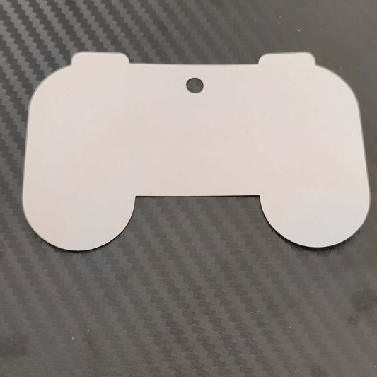 Hollow outline of a gaming controller gift tag on black carbon fiber background for personalized gifts.