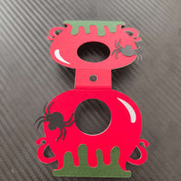Red and green Halloween lollipop holder designed like a cauldron with spider embellishments.