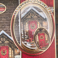 Christmas card in progress showing background design of a red door cottage scene with oval frame toppers ready for layering.