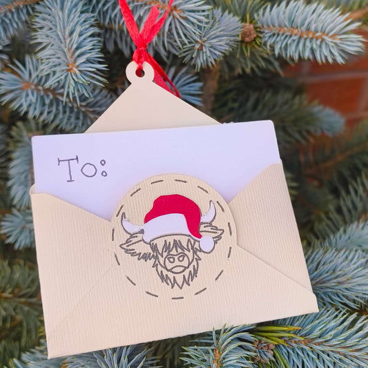 Outdoor pine tree decorated with handmade Christmas envelope ornament for money or gift cards