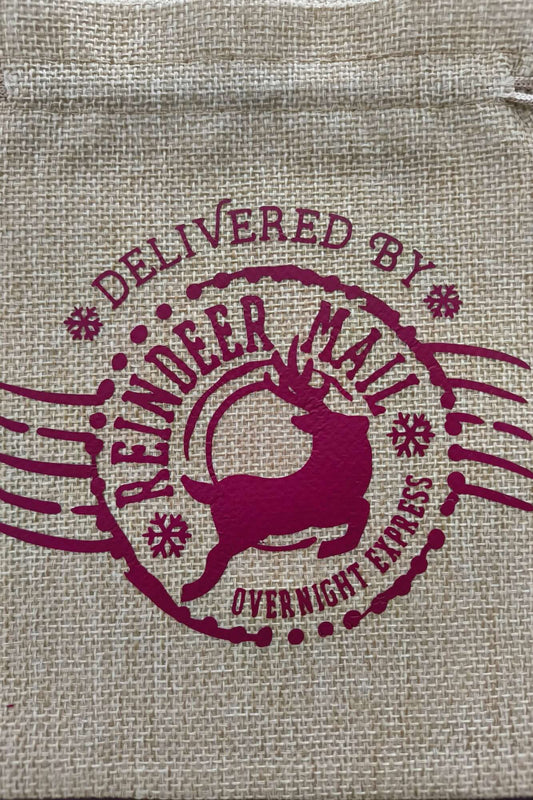Close-up of reindeer and "Delivered by Reindeer Mail Overnight Express" text in burgundy print on natural hessian bag.