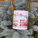 Christmas mug with festive train design hanging on blue spruce tree branch outdoors