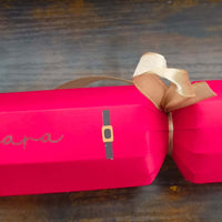 Personalised red Christmas cracker with gold ribbon and Santa design, adding festive charm to your holiday table.