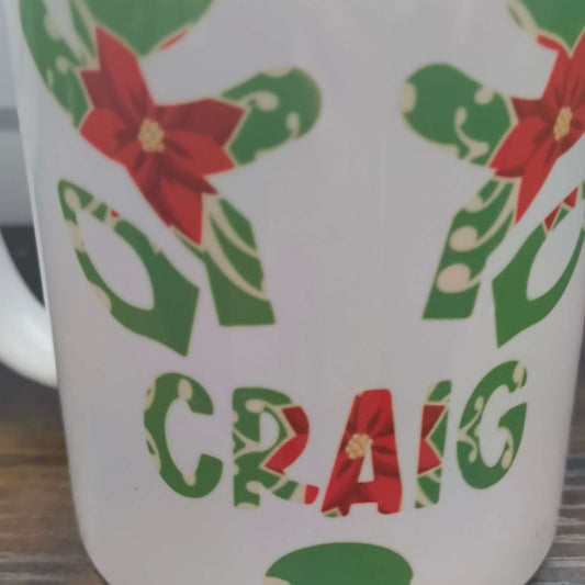 Personalised Christmas mug featuring poinsettia and holly design with the name Craig.