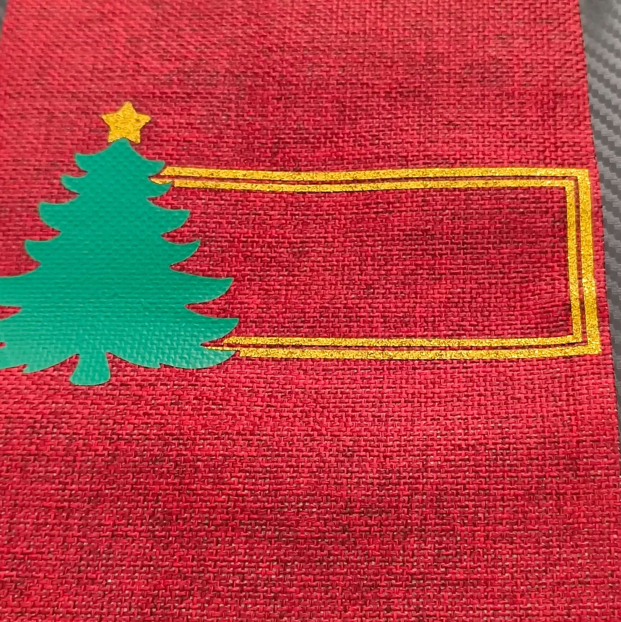 Personalised Christmas wine bottle bag in red hessian with green tree design and gold frame for a custom name.