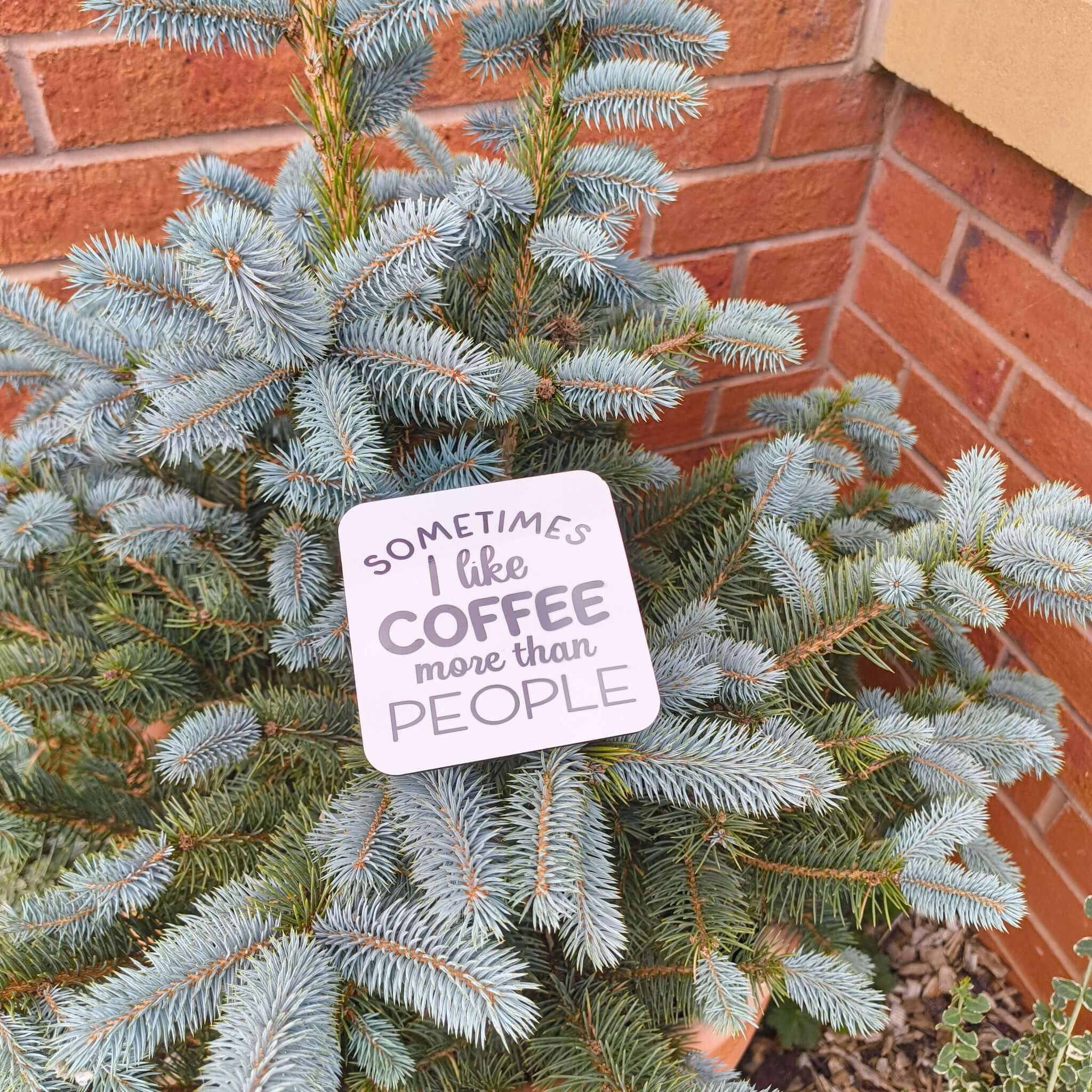 Funny coffee coaster gift with the phrase 'Sometimes I like coffee more than people' on a tree.