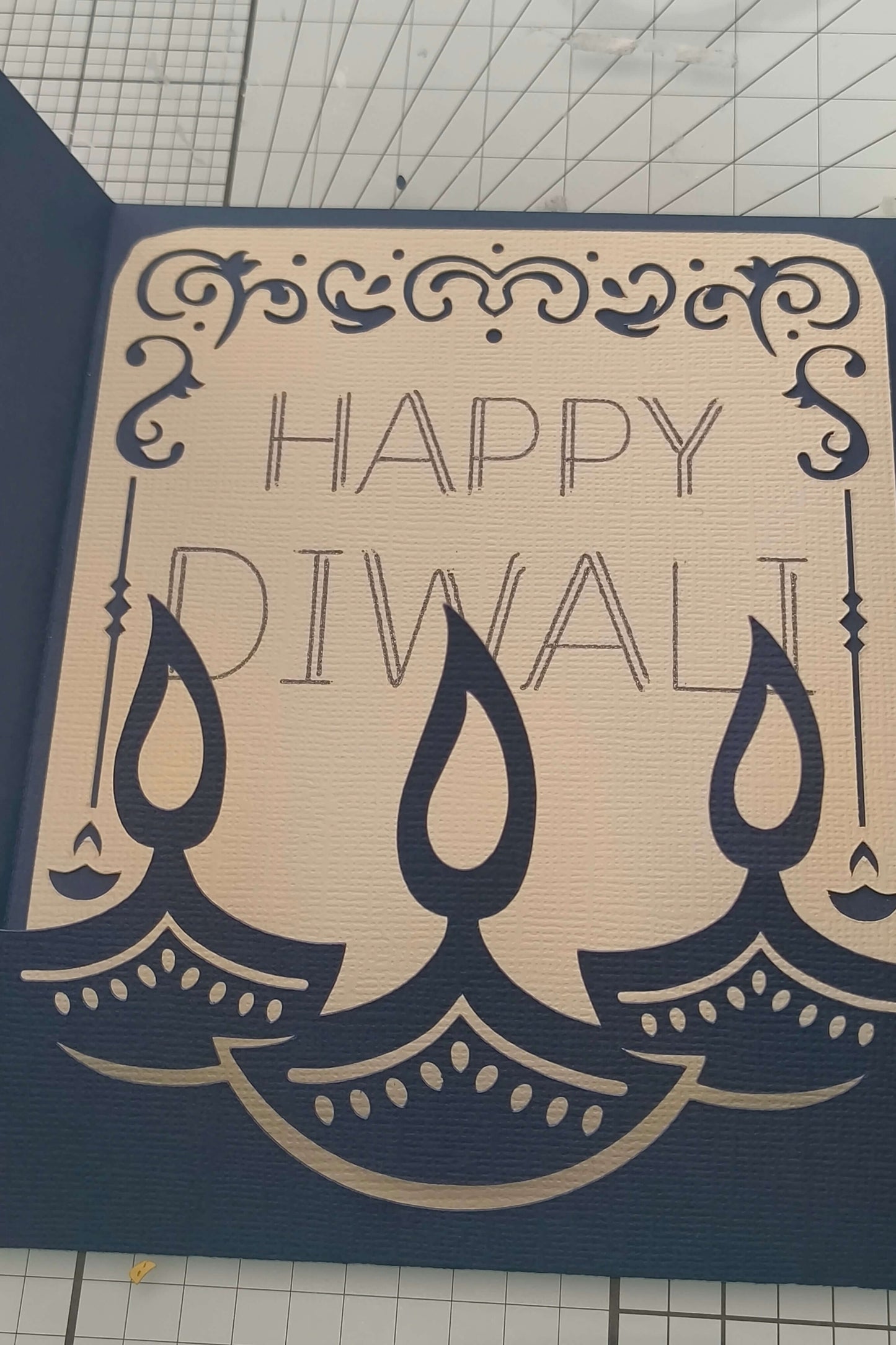 Handmade Diwali card featuring intricate design with the text 'Happy Diwali' and decorative oil lamps.