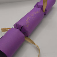 Purple Diwali cracker with shimmering gold foil “Happy Diwali” design and satin ribbon ties at each end.