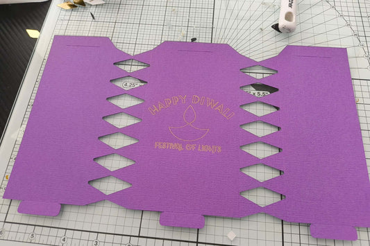 Purple card cracker template with diamond cut-outs and gold foil “Happy Diwali Festival of Lights” design, ready for folding and assembly.