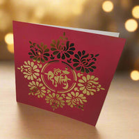 Personalised red and gold Diwali greeting card with intricate floral laser-cut design and 'Shubh Diwali' message, displayed on a wooden surface