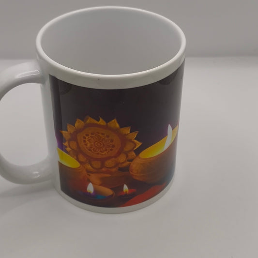 White ceramic mug featuring a Diwali design with glowing diyas and a golden mandala pattern, photographed on a clean white background to show the vibrant print detail.