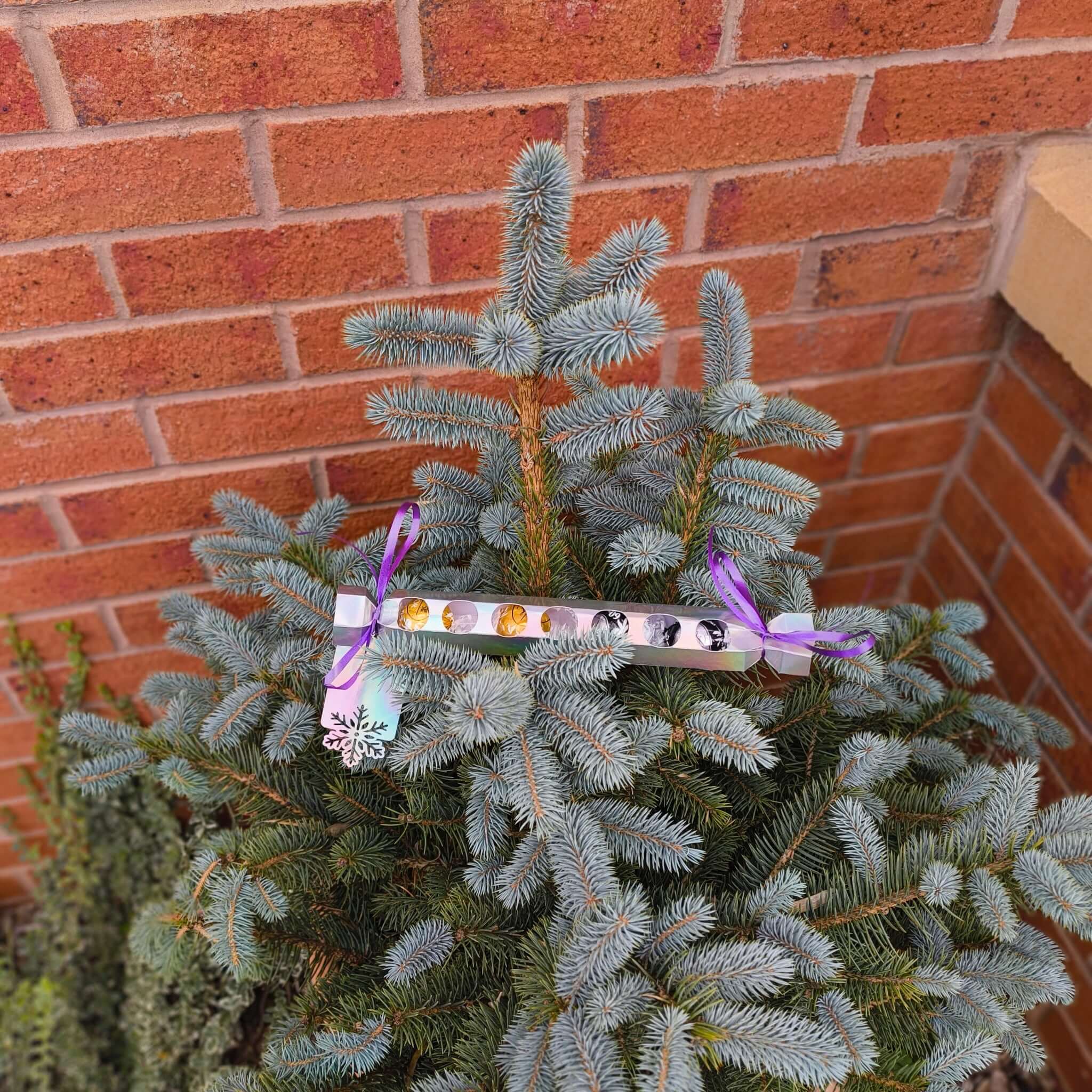 Personalised chocolate cracker gift displayed on a festive tree for Christmas celebration.