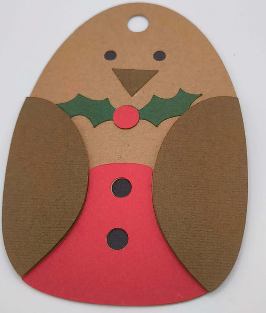 Close-up of festive robin-shaped Christmas gift tag with red belly and holly decoration.