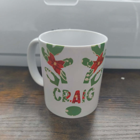 Personalised Christmas mug with poinsettia and holly design featuring the name Craig.