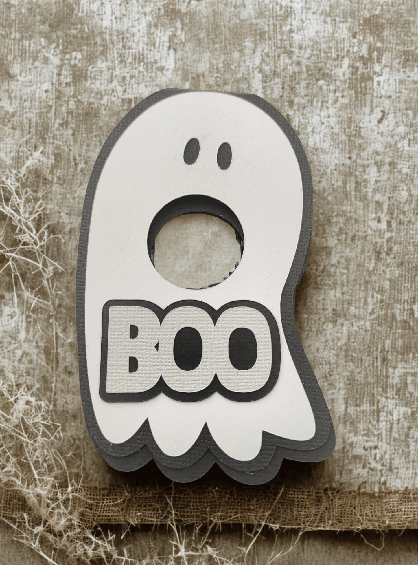 Cute ghost-shaped holder with 'BOO' text, perfect for Halloween lollipop treats.