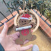 Handmade gingerbread man ornament held outdoors, showing money holder feature and hanging jute string.
