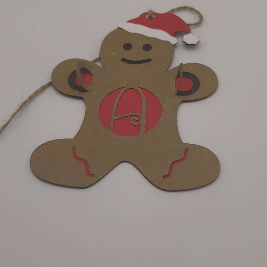 Handmade gingerbread man ornament with red monogram letter A and Santa hat, made from layered cardstock with jute string.