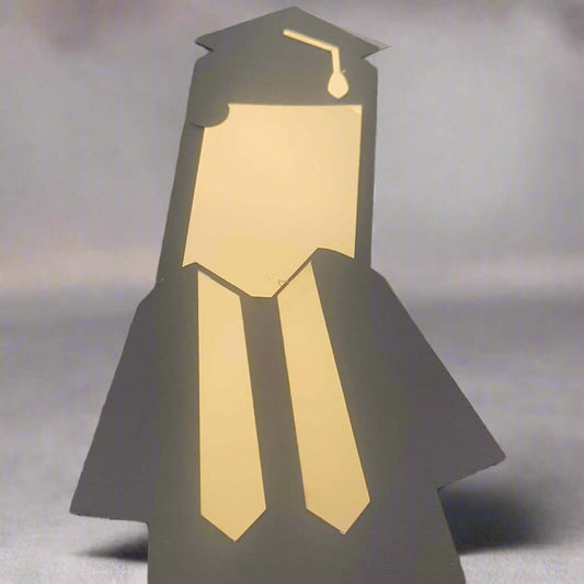 Graduation gift card holder shaped like a graduate in cap and gown with gold foil details, perfect for celebrating student achievements