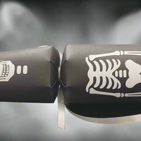 Close-up of black Halloween cracker featuring skull and ribcage skeleton design with silver ribbon.