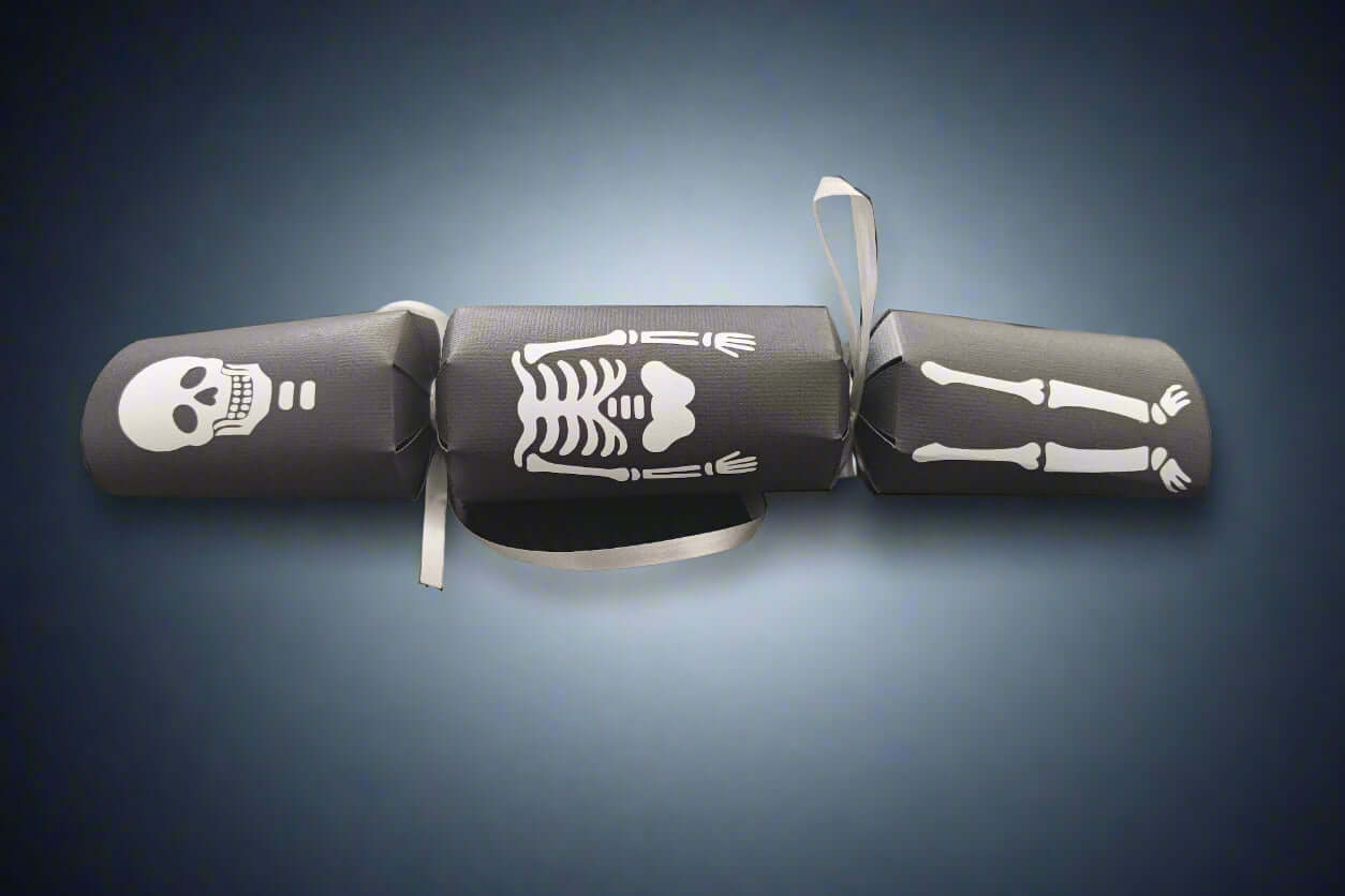 Black Halloween cracker with white skeleton design showing skull, ribcage, and legs tied with silver ribbon.