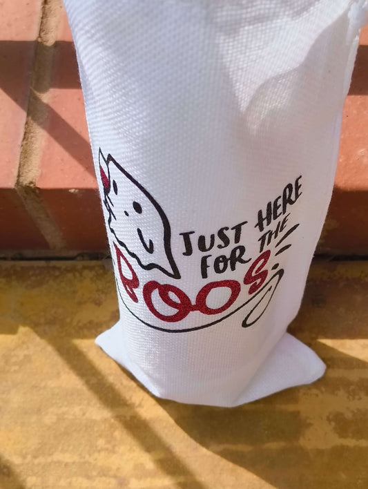Close-up of Halloween wine bag with ghost and glitter red "BOOS" text, showing textured white fabric and bold design.