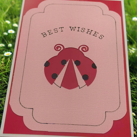 Handmade "Best Wishes" greeting card featuring a layered pink and red design with a cute ladybird illustration and elegant black text, perfect for birthdays, congratulations or general well wishes.