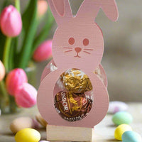 Handmade bunny-shaped Easter chocolate holder with Lindor truffles, decorated with pastel eggs and tulips.