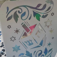 Handmade Hanukkah card with dreidel and Star of David cut-out design, holographic background